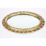 A Victorian gilt framed oval mirror, the plate inside a pierced, scrolling frame,