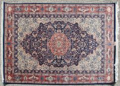 A Persian carpet, the central floral cartouche on a blue and cream field,