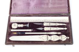A 19th century cased ivory stationery set including a quill pen, openers, wax seal and a rule edge,