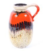 A West German lava vase, with vibrant orange, brown and speckled ivory glaze, with strap handle,