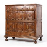 A Carolean style oak chest of drawers, the front moulded with geometric panels,