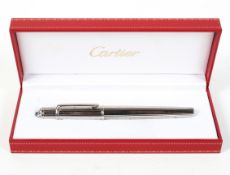 A Cartier ballpoint pen, in presentation box, the white metal case of reeded form,