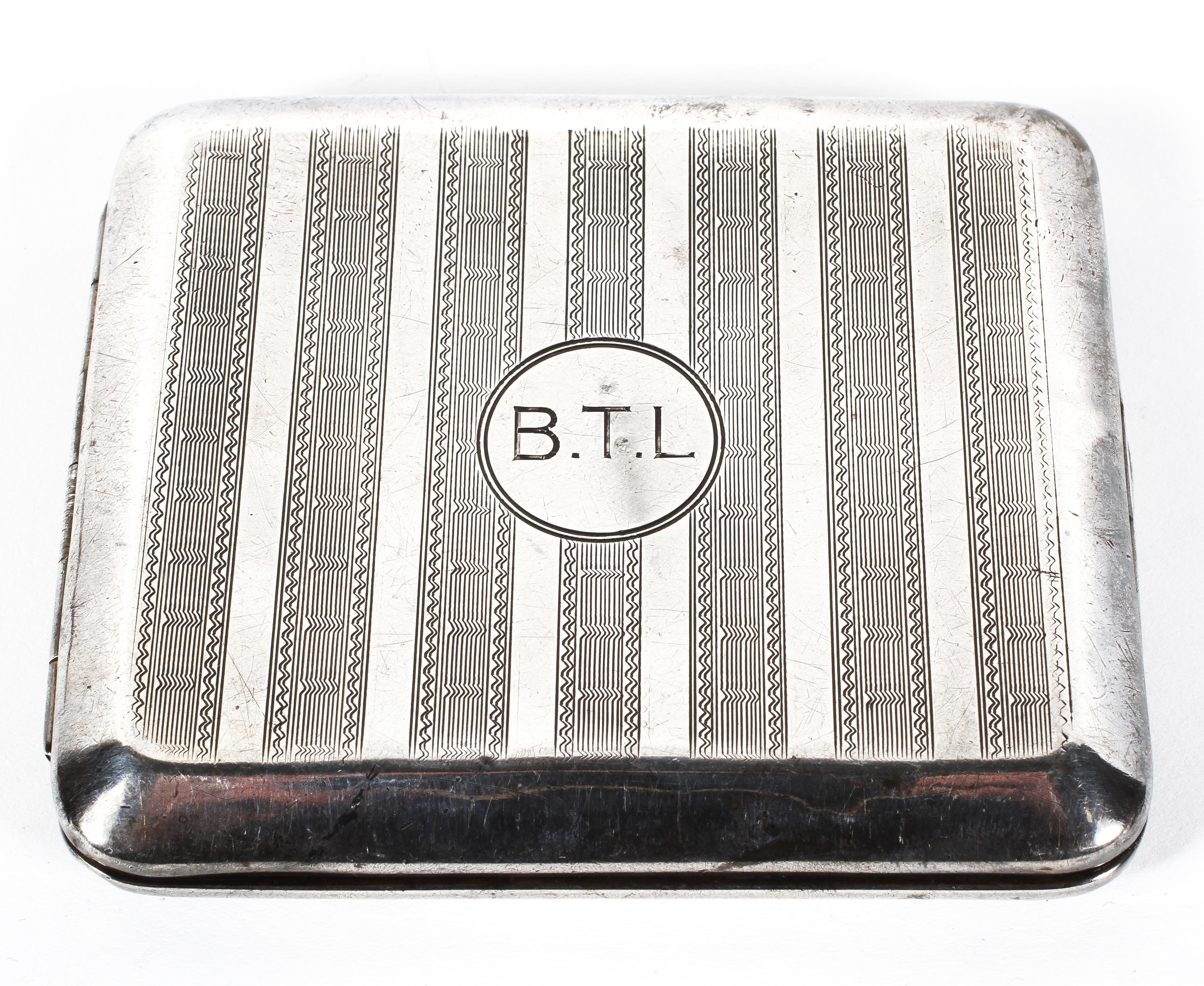 A George V silver cigarette case of rectangular form, adorned with initials "BTL" to front,