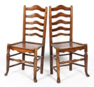 A pair of elm kitchen chairs, with ladder backs and plain seats, on rounded legs,