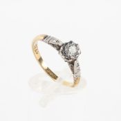 A yellow and white metal ring principally set with a round brilliant cut diamond