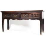 An 18th century oak dresser base, with two short drawers carved with recessed flutes,