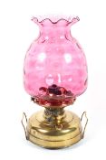 A large cranberry glass and brass oil lamp, early 20th century,