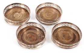 A set of four silver plated and turned wood coasters, early 20th century,