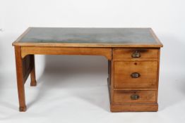 An Edwardian oak desk, the rexine inlaid top above twin pedestals,