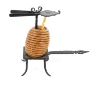 A metal wax jack, with wax coil mounted on a stand with pierced handle, below pincers,