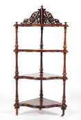 A Victorian corner four tier whatnot, of serpentine outline,