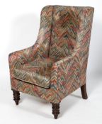 A Victorian wingback armchair, with loose seat cushion and turned front legs,