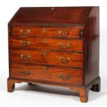 A George III mahogany bureau, the fall front enclosing a fitted interior, above four cock beaded,