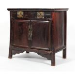 An Chinese ebonised hardwood cabinet, with two drawers above two panelled doors, with brass mounts,