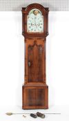 An early 19th century mahogany long case clock, the arched glazed hood with reeded columns,