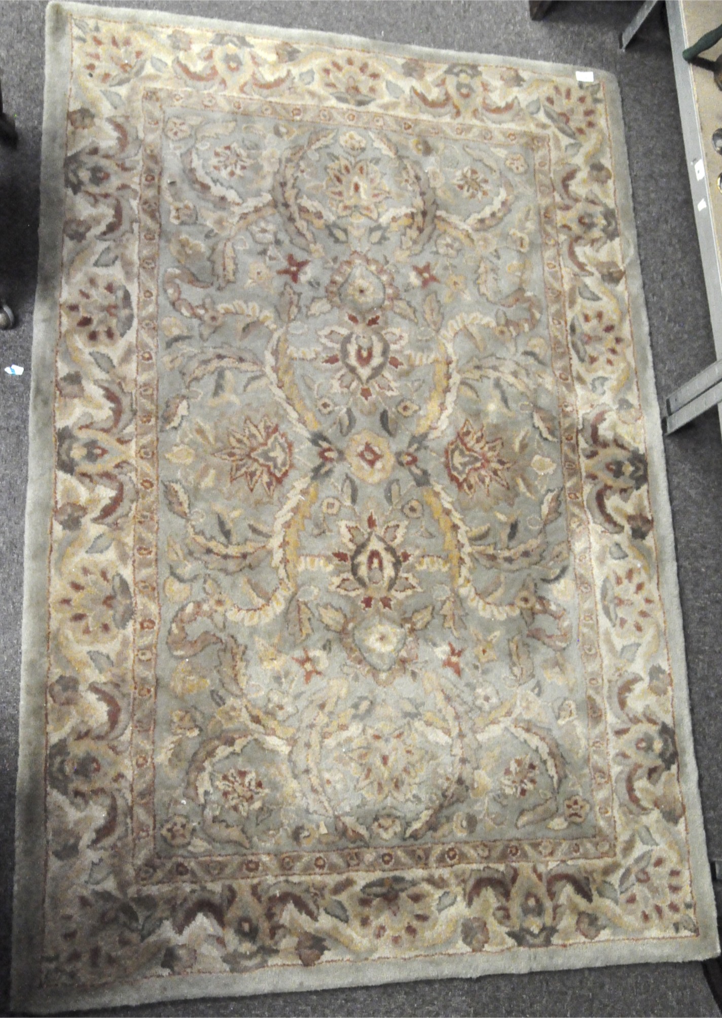 A 20th century rug with a pale green and russet floral and leaf pattern,