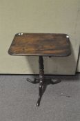 A 19th century oak tripod table with rectangular top on turned baluster column and tripod base,