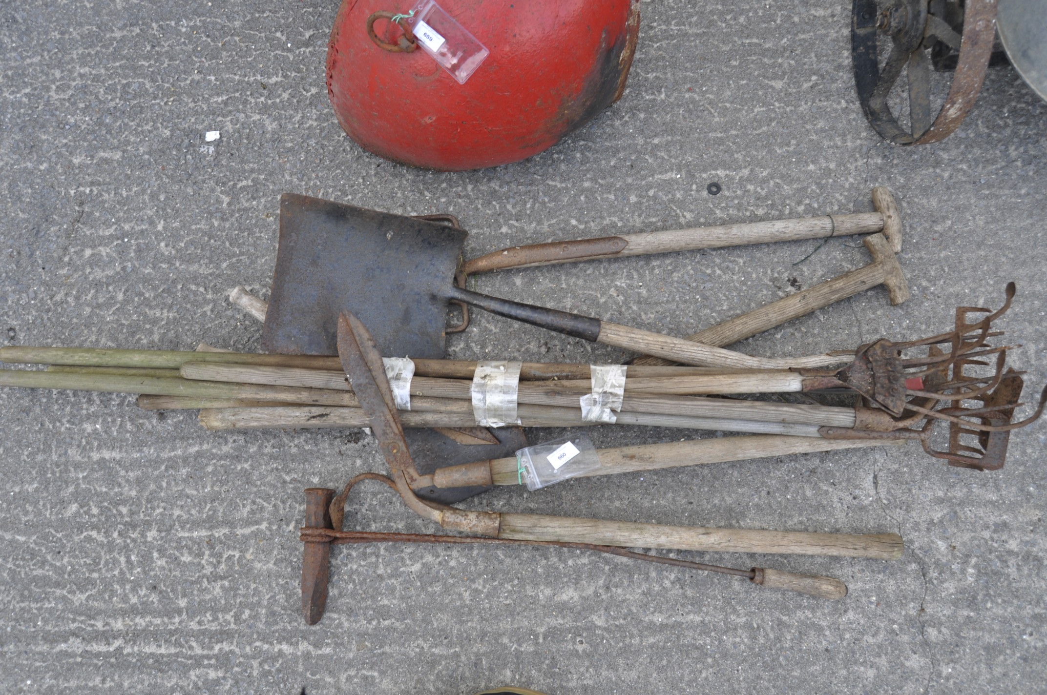 A large quantity of garden tools, including forks, spade etc