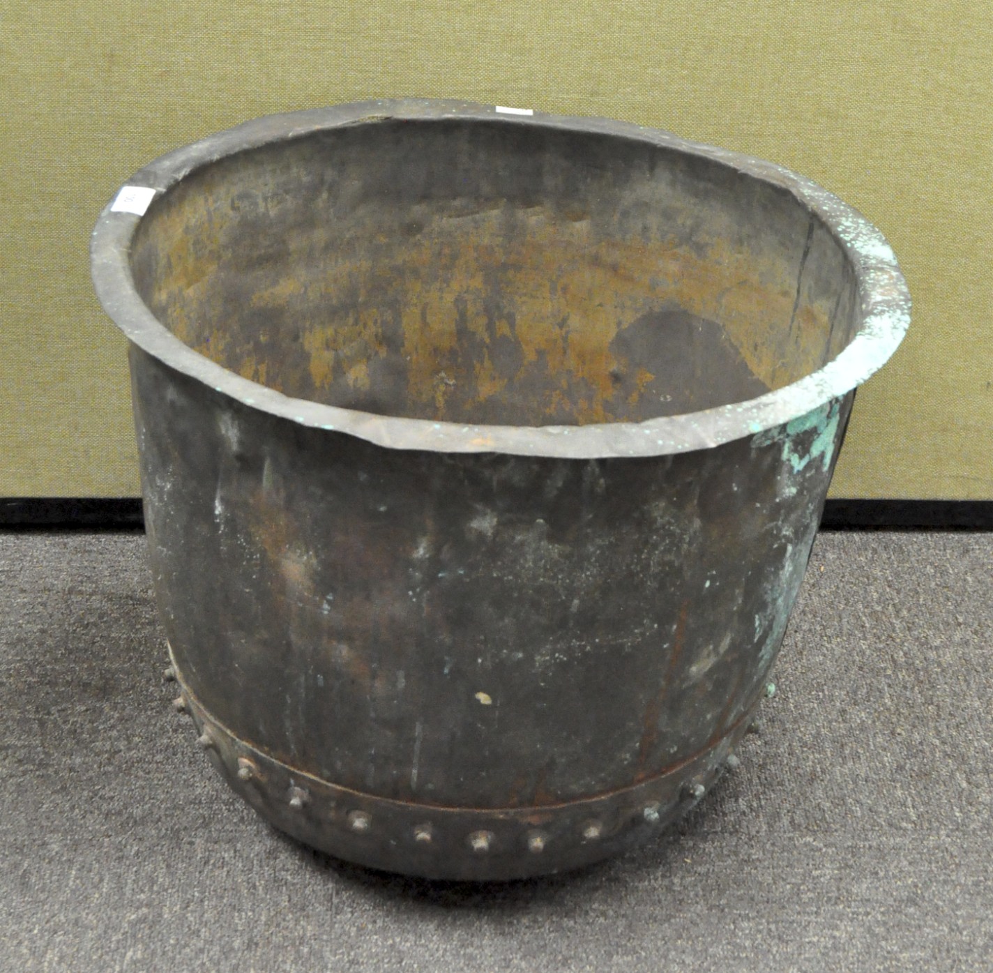 A 19th century copper bucket with flattened rim, riveted seams and verdigris patination,