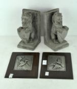 A pair of stone bookends modelled as lions holding shields,