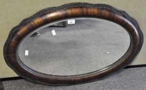 A mahogany wall mirror, with cushion-shaped frame, beeded and wave ornament,