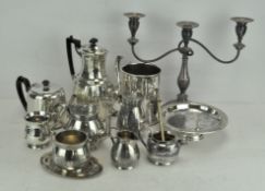 A large selection of silver plate to include a wine bottle stand, tea sets, candelabra,