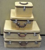 A set of four 1950's fitted suitcases and vanity case in pale yellow woven material
