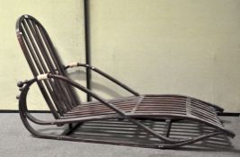 A slatted and stained wooden reclining chair, the elongated frame representing a sleigh,