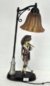 A contemporary lamp, modelled as a woman in Art deco attire standing underneath a lamp post,