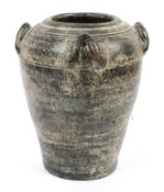 A black glazed terracotta tapering urn, with upright loop handles, reeded body,