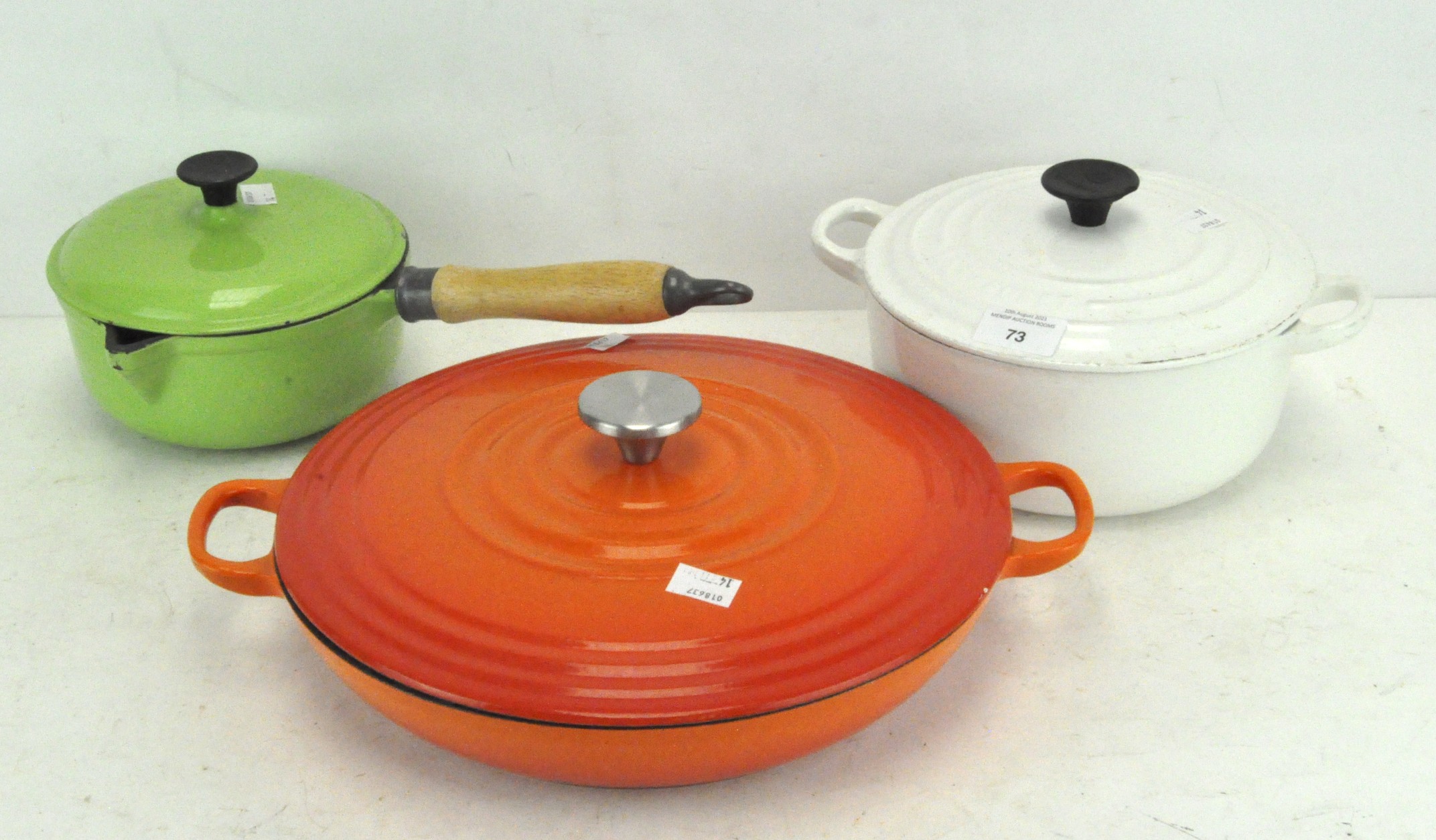 Three Le Creuset pans in assorted colours,