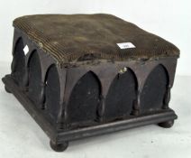 A late 19th century foot stool, with arched mhaogany panels, on bun feet,