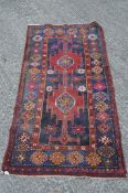 An Iranian rug, 20th century, woven with geometric ornament in pink, red, blue and orange,