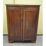 An early 20th century mahogany cupboard with two shelves behind double doors raised on shaped feet,