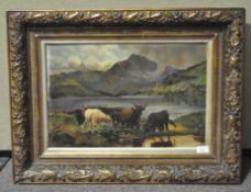 A early 20th century oil on canvas, depicting highland cows grazing beside a lake,
