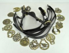 A leather horse bridle and quantity of horse brasses