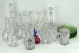 A collection of assorted cut and moulded glassware, comprising three decanters, ten green plates,