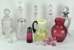 A selection of glassware including a silver collared decanter, cranberry glass sugar shaker,