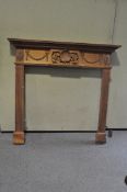 A 20th Century wooden fire surround, carved with details of wreaths, flowers and vines,