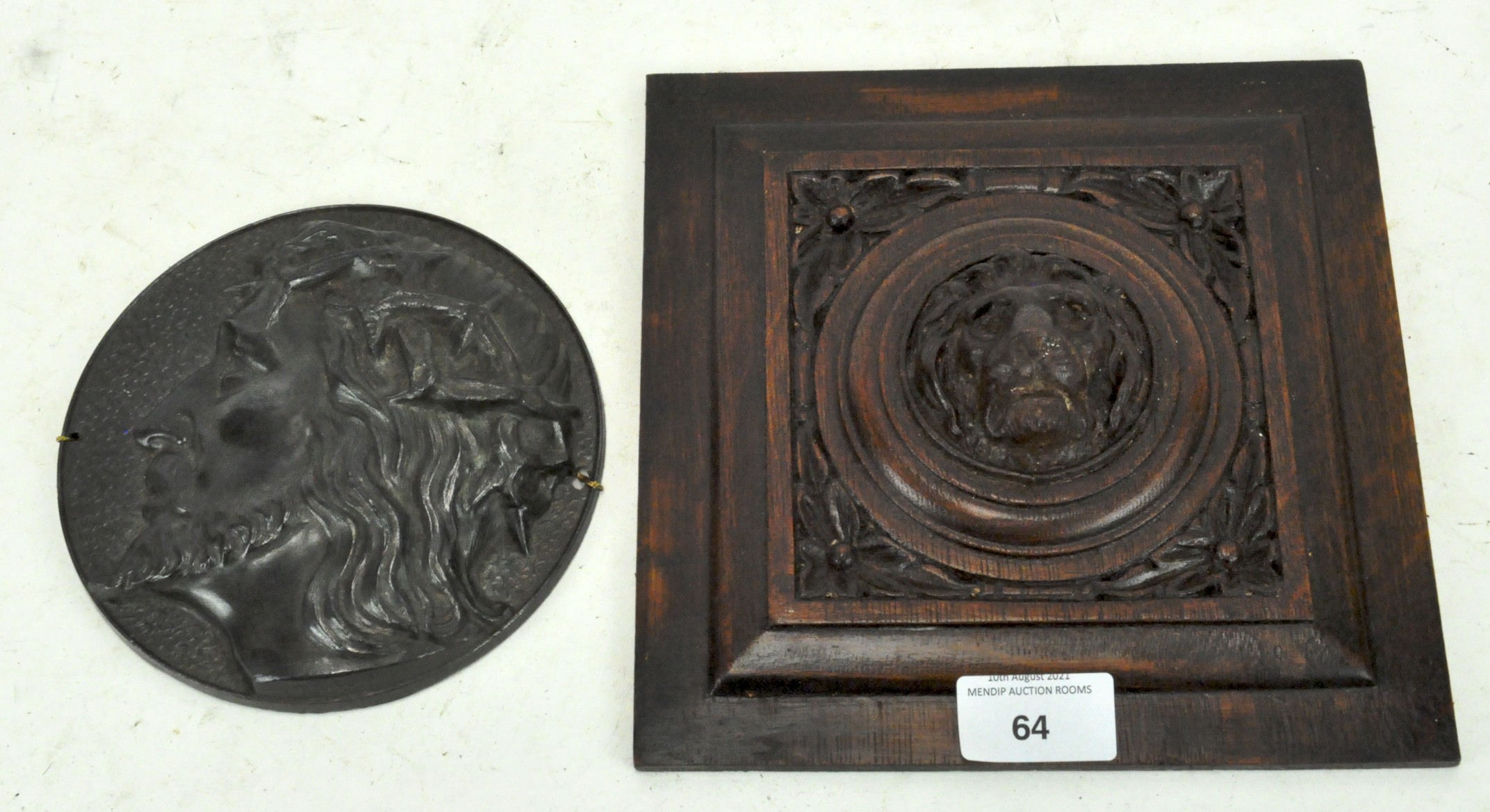 A carved wooden wall plaque featuring a lion to the centre,