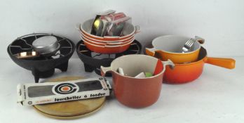 A group pf Le Creuset items including two fondue sets, forks,