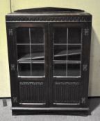 A early 20th Century glazed oak cabinet having twin leaded glazed doors and adjustable shelves,