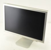 An Apple 21" computer screen with cable on a stand,