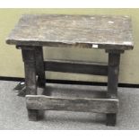 A rustic wooden bench with sloping footrest,