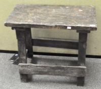 A rustic wooden bench with sloping footrest,