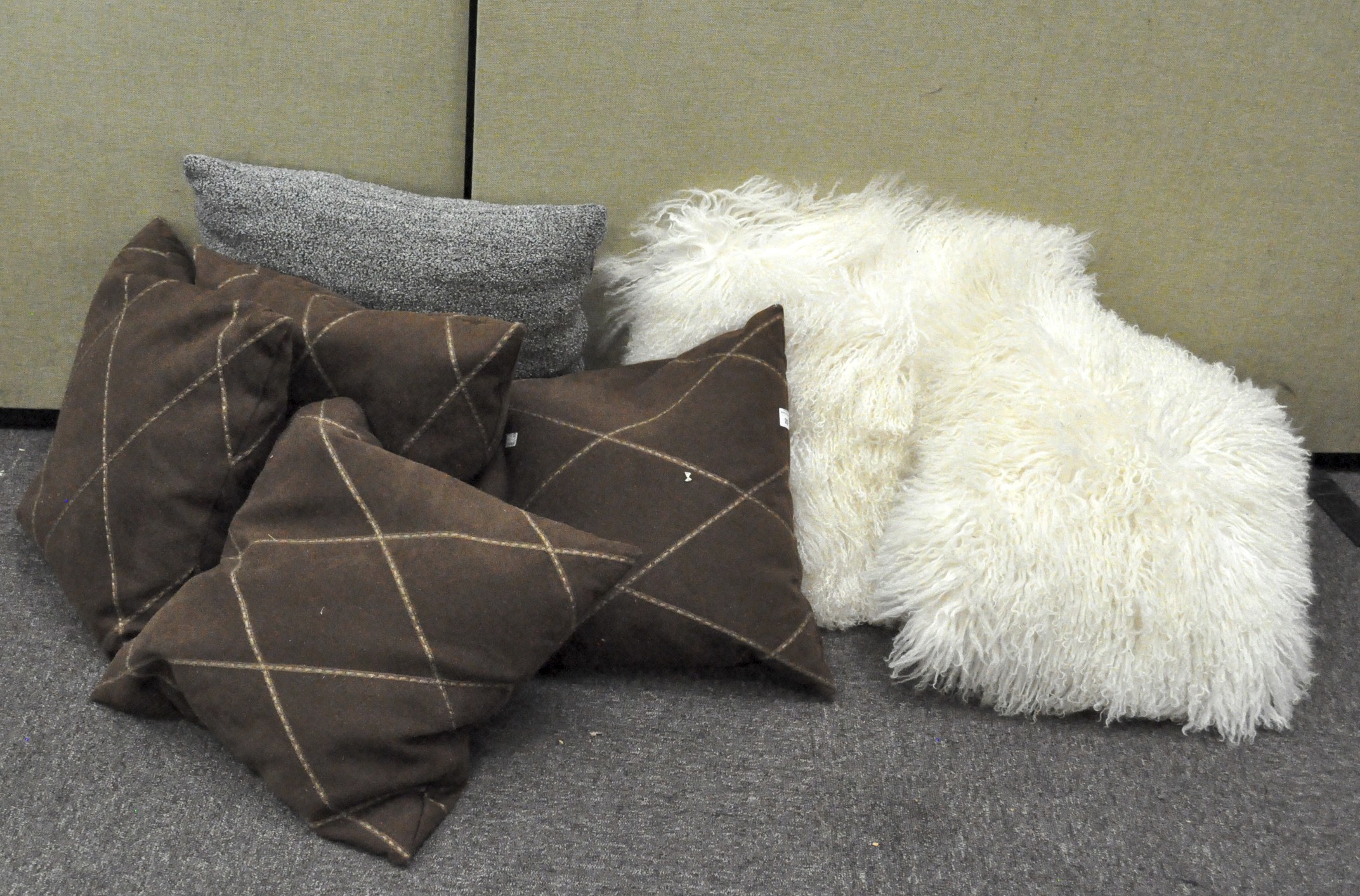 A collection of contemporary cushions, comprising four in brown suede,
