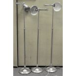 Three modern chrome standard lamps with swivel head and bowl shades on a round foot,