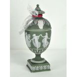 A Wedgwood dipped green jasperware vase and cover with handles and raised on a plinth,