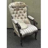 A Victorian button back armchair with scroll arms and turned legs on casters,