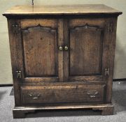 A 20th century oak side cabinet (back missing) with double doors above a drawer on runners,